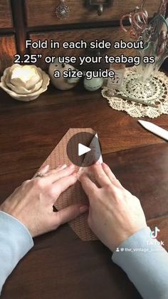 a person is making a piece of wood with scissors and tape on it, sitting at a table