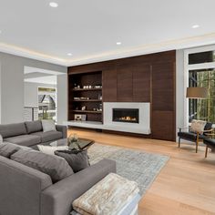 a large living room with wood floors and gray couches