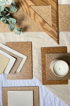 cork placemats and coasters on a table with a white candle, succulent