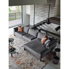 a living room filled with furniture and a stair case next to a large window on top of a carpeted floor