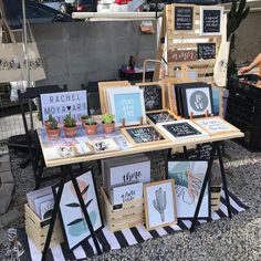 a table with pictures and signs on it in front of a store selling handmade items