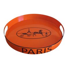 an orange tray with the words paris on it and a horse drawn carriage in black