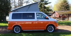 an orange and white van is parked in the grass