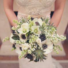 a bride holding a bouquet of white flowers