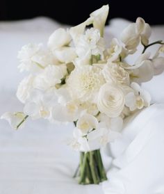 a bouquet of white flowers sitting on top of a bed