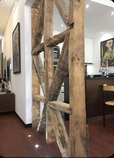 a large wooden structure sitting in the middle of a living room next to a kitchen