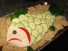 a fish made out of crackers and cucumbers