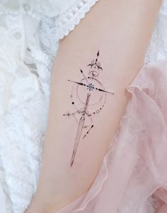 a woman's arm with a tattoo on it that has an arrow in the center