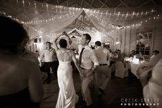 the bride and groom are dancing at their wedding reception in black and white photo by creek street photography