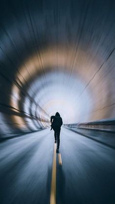 a person riding a skateboard through a tunnel