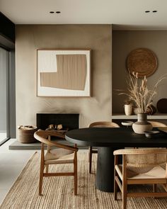 a dining room table and chairs in front of a large window with an abstract painting on the wall