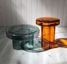 two glass tables sitting next to each other on top of a wooden tablecloth covered floor