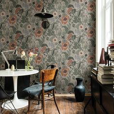 a room with a table, chair and vase on the floor in front of it