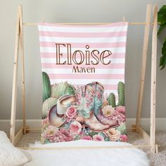 a pink and white striped wall hanging with an image of cowboy boots on the ground