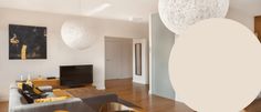 a living room filled with lots of furniture and white balls hanging from the ceiling above