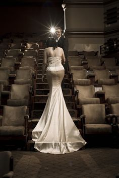 a man and woman standing in front of rows of chairs