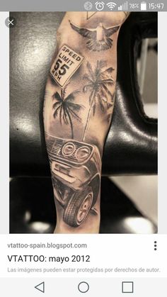 a man's arm with tattoos on it and an image of a car in the background