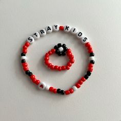 a red, black and white beaded bracelet with the words straykids on it