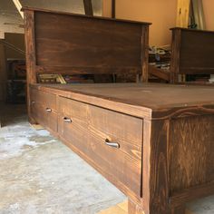 a wooden bed frame with two drawers on each side