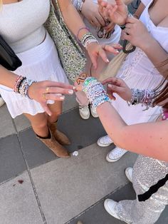 a group of women standing next to each other with bracelets on their wrists and hands