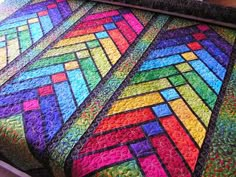 a multicolored quilt is displayed on a table