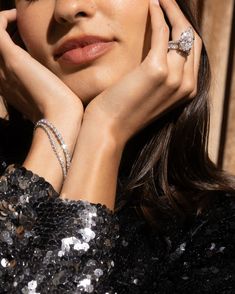 a woman with her hands on her face wearing two rings and one ring in front of her face