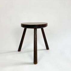 a small wooden stool sitting on top of a white floor