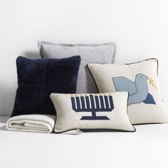 pillows and blankets are arranged on a white surface, including one with a hanukkah menorah symbol