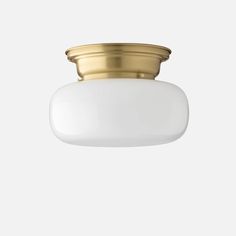 a brass ceiling light with a white glass shade