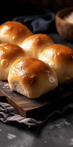 four loaves of bread sitting on top of a cutting board