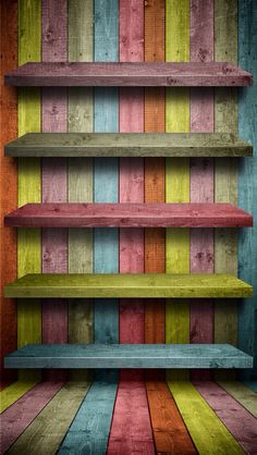 an old wooden shelf with multicolored paint on the wall and flooring in front of it