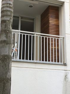 an apartment balcony with wooden shutters and white balconies