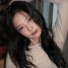 a young woman with long black hair is posing for the camera and holding her hands behind her head