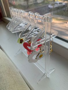 a window sill with several pairs of earrings hanging from it's hooks and hangers