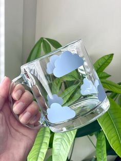 Serve your next drink from this cute cloud cup! This adorable 13 oz (384 ml) glass mug is perfect any beverage - sodas, iced coffee, or anything really! It's the perfect gift for birthdays, house warming or for any other any occasion! Glass Mug Care * Hand wash ONLY * Do not soak  * Dry with soft towel * Do not put in microwave NOTE: Since the designs on these cups are made with permanent vinyl, which is essentially a sticker. These designs are not meant to last forever, the longevity is based o Rain Cloud Mug, Glass Drinking Cups, Cute Cups And Mugs, Clear Mugs With Vinyl, Cute Coffee Mugs Designs, Cup Decoration Ideas, Glass Mugs With Vinyl, Mug Ideas Design, Cricut Glass Cups