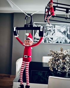 the elf is hanging upside down from the ceiling