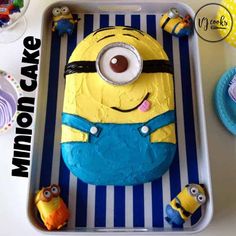 a birthday cake that looks like a minion is on a tray with other decorations