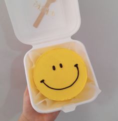 a yellow smiley face in a plastic container