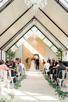 a bride and groom standing at the end of their wedding ceremony in an indoor chapel