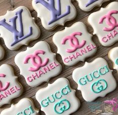 decorated cookies with chanel and gucci logos are displayed on a wooden table top