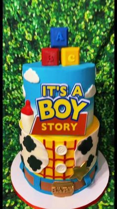 a toy story cake with blocks on top and the words it's a boy