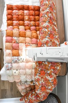 the sewing machine is next to an orange and white quilt