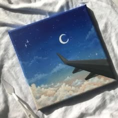 a painting of an airplane flying in the sky with a crescent moon and stars painted on it