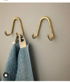 two towel hooks are hanging on the wall