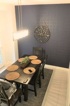 a dinning room table with place mats and plates on it, in front of a blue wall