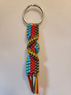 a pair of multi colored beads on a metal keychain hanging from a hook