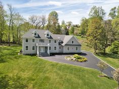 an aerial view of a large house in the middle of a lush green field with trees