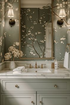 a bathroom vanity with a mirror and flowers painted on the wall behind it in shades of green