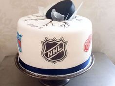 a hockey themed cake with the logo of the new york rangers and an ice hockey stick on top