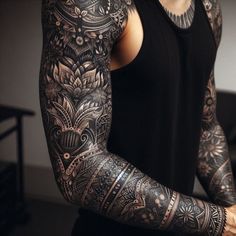 a man with tattoos on his arm and shoulder